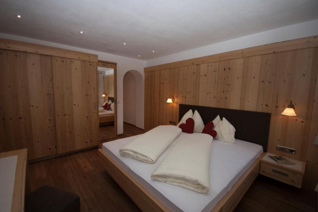 塞斯托Landhaus Summerer的卧室配有一张白色大床和木墙