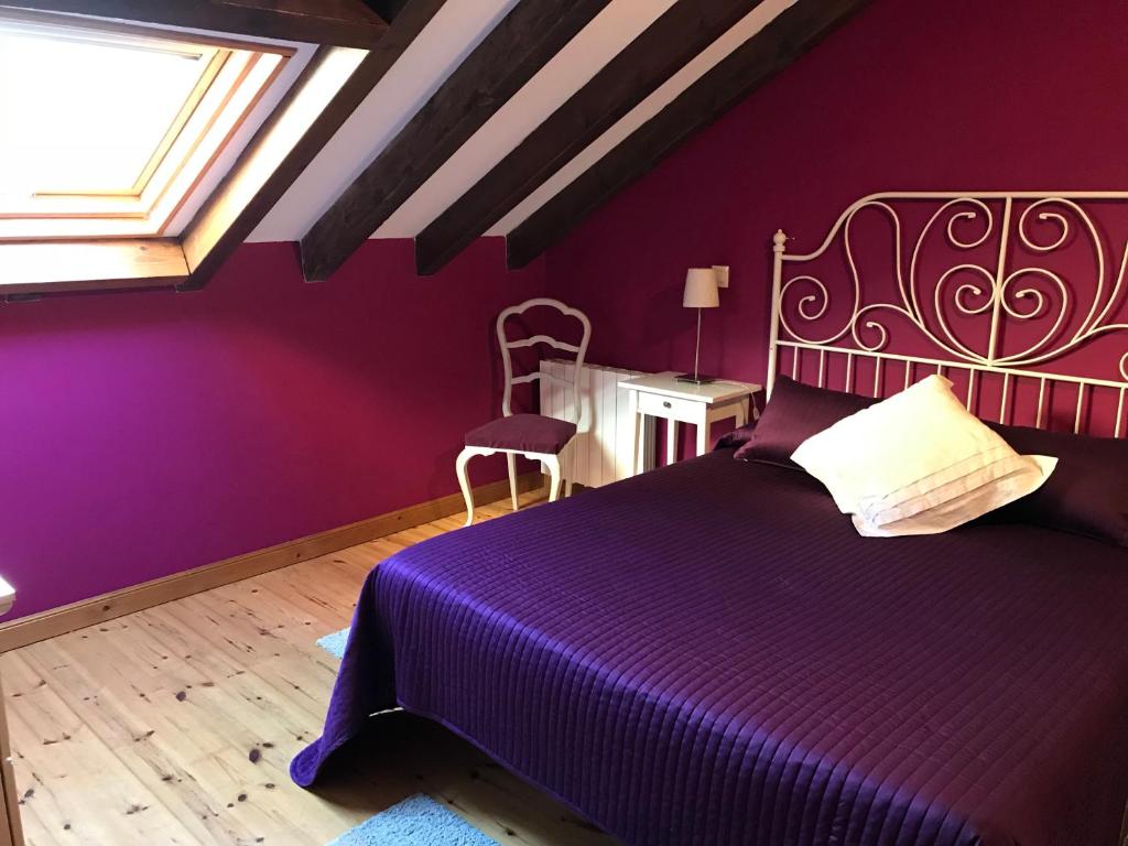 桑提亚纳德玛En busca del viento del norte的紫色卧室设有一张床和一个窗户