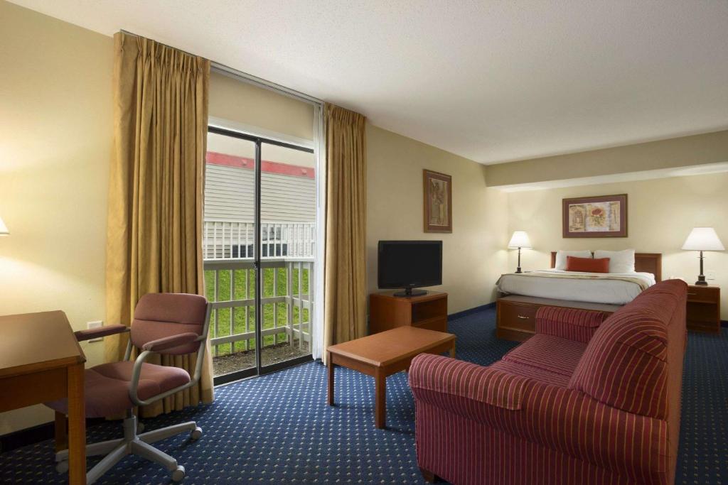 大急流城Affordable Suites of America Grand Rapids的酒店客房设有一张床和一个阳台。