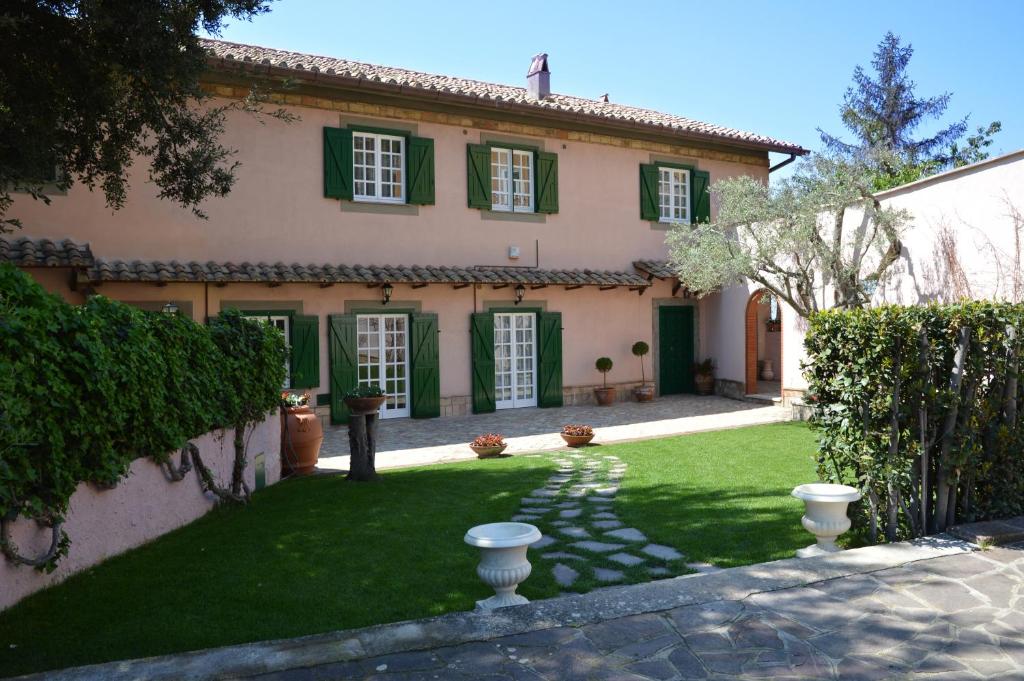 蒂沃利Antica Villa di Bruto的一座带绿色百叶窗和庭院的古老房子