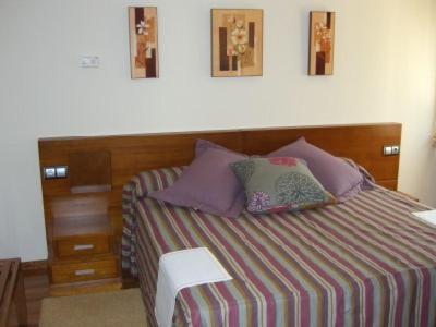诺盖拉德拉姆达雷萨赌场酒店的一间卧室配有一张带木制床头板的床