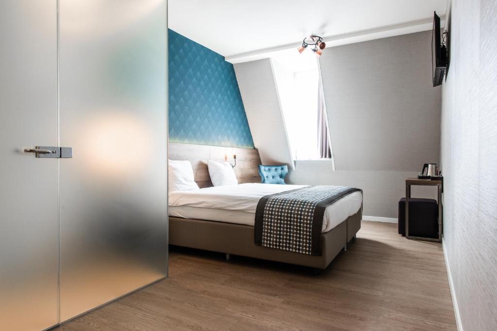 阿姆斯特丹Melrose Hotel的一间卧室配有一张蓝色墙壁的床