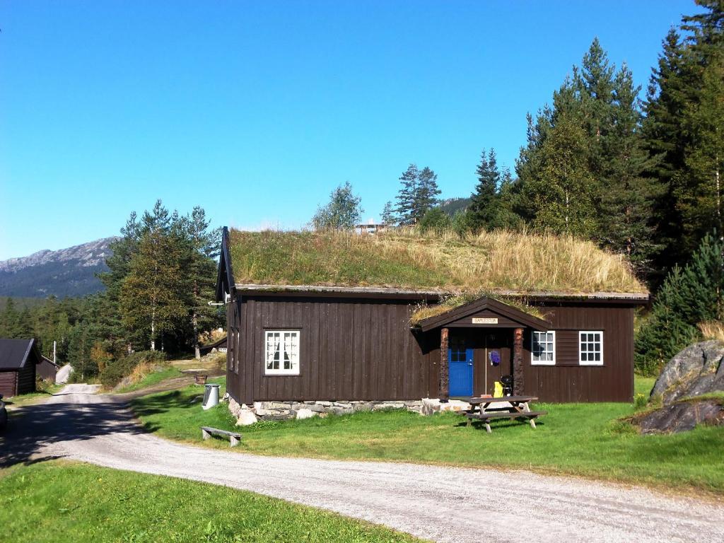 TuddalHogstul Hytter - Gamlestua的带有草地屋顶的建筑,有碎石路