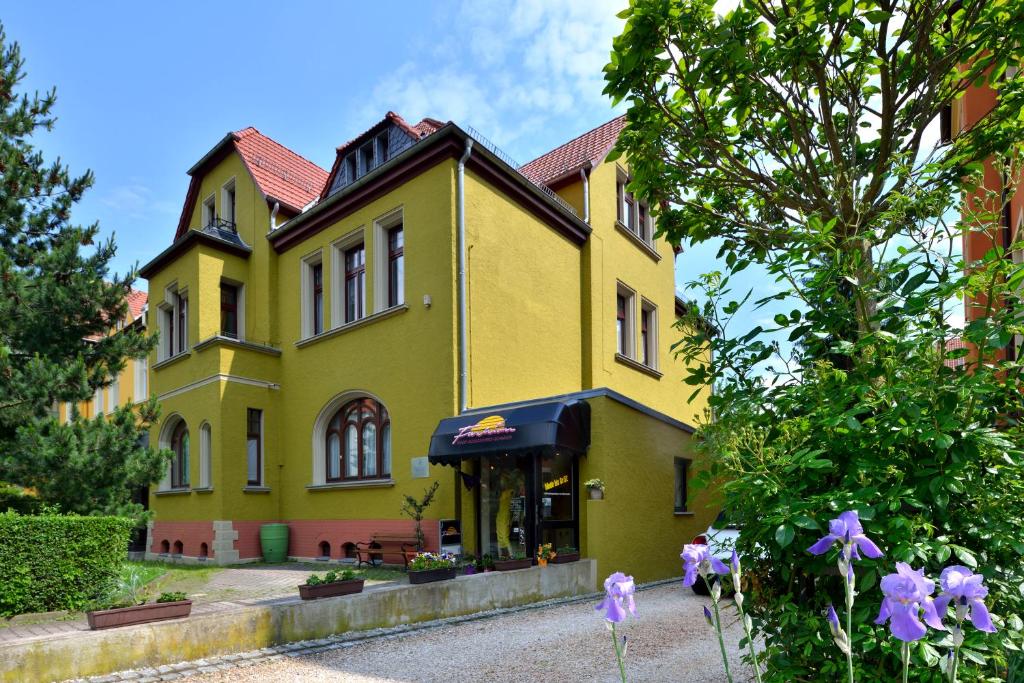 哥达Schlossblick Apartment的黄色房子前面有紫色的花