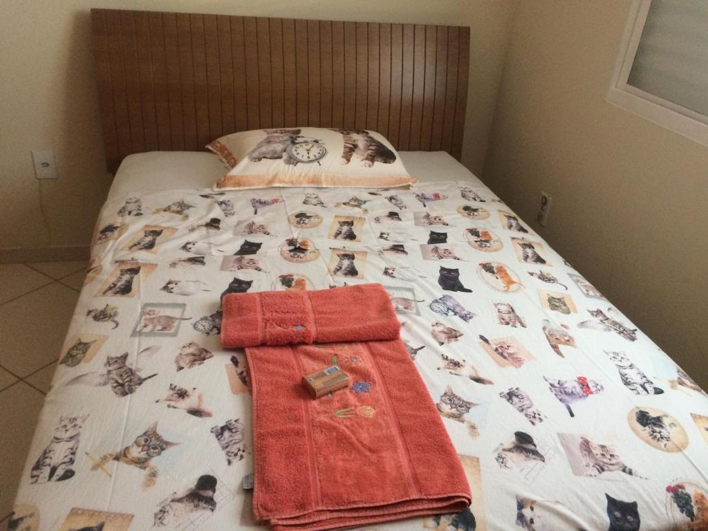 伊塔佩鲁纳Casa da Jussara的一张床上,床上挂着一条毯子,上面有狗的照片