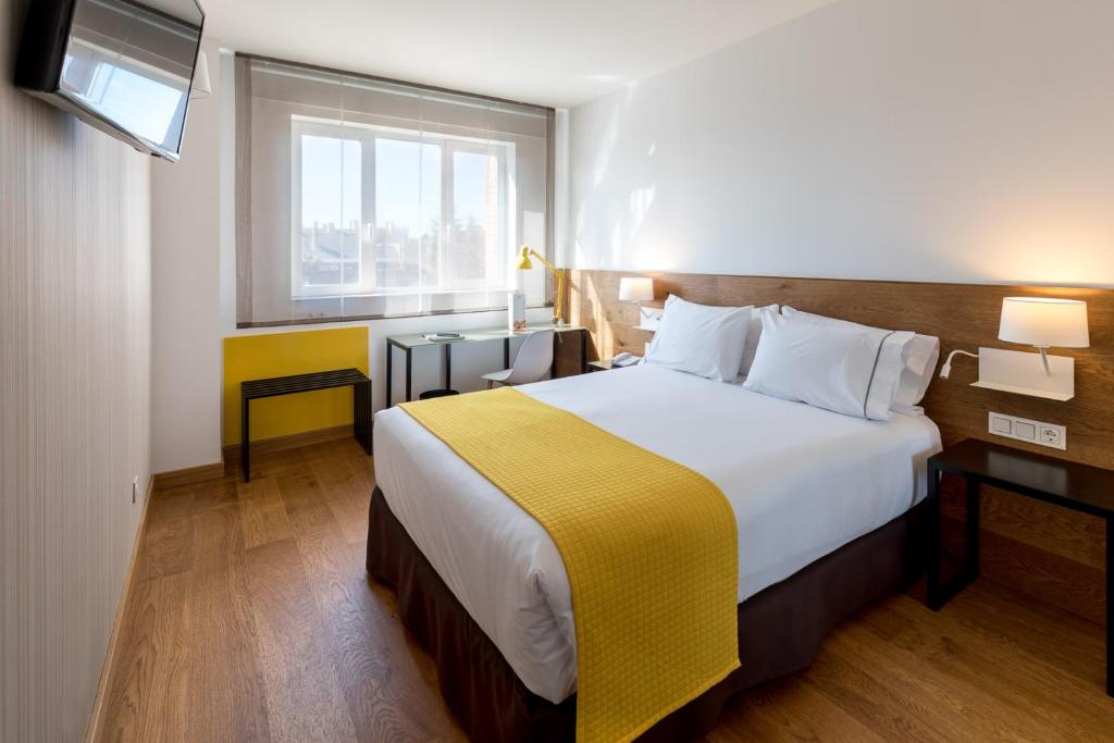 马德里拉斐尔阿托查酒店的一间设有大床和窗户的酒店客房
