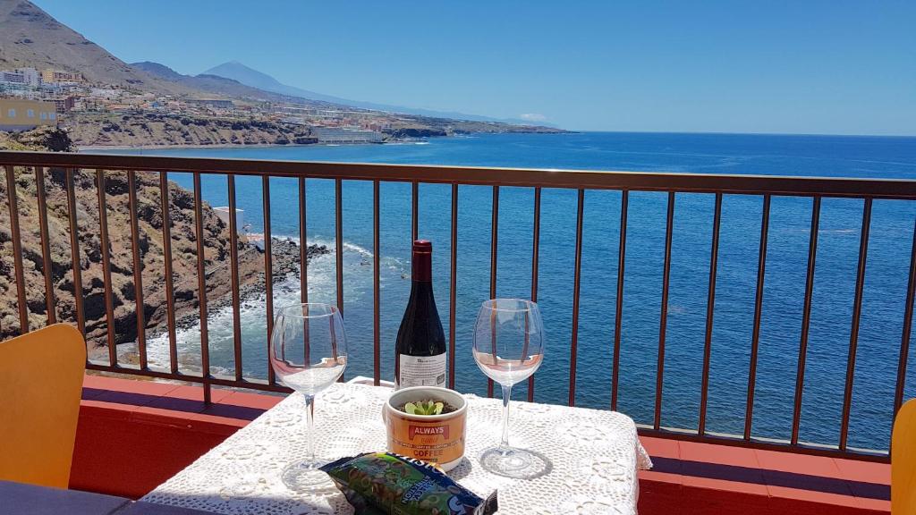 蓬塔德尔西达尔戈Hoya Baja 26的阳台上的桌子和两杯葡萄酒