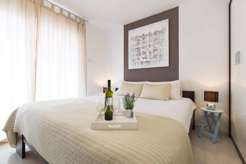 普纳特Apartments M&T Mirna的一间卧室配有一张床,提供两瓶葡萄酒