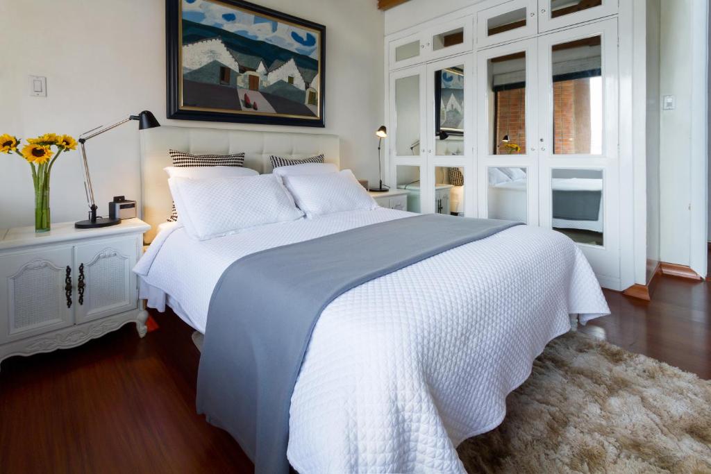 基多Penthouse Lodge B&B的白色的卧室设有一张白色大床和一个窗户。