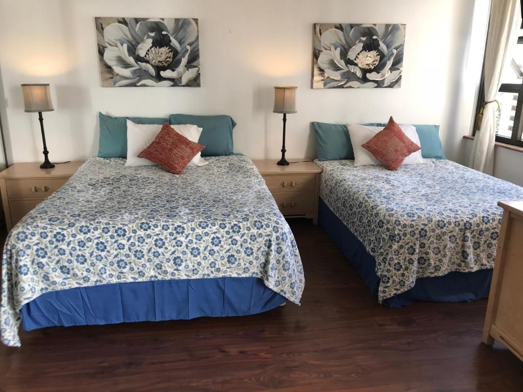 檀香山Waikiki Banyan的一间卧室配有两张床和两盏灯。