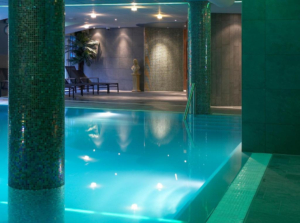 赫鲁斯贝克Hotel & Appartementen - De Zeven Heuvelen的蓝色建筑中的游泳池