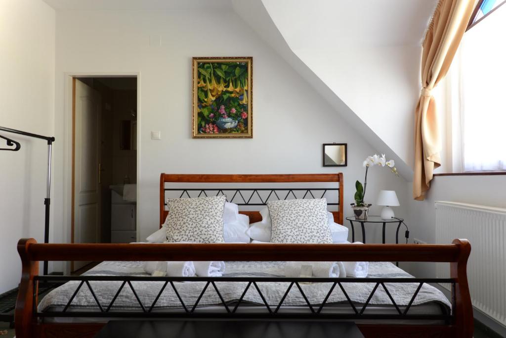 陶波尔曹Malom Vendégház Tapolca的一间卧室配有带白色枕头的木床