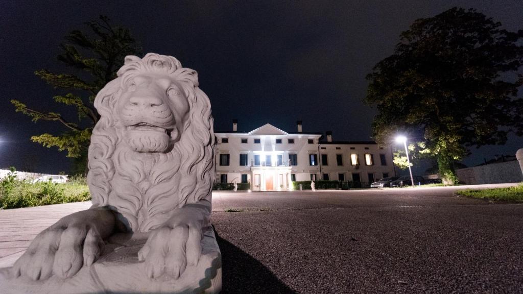 阿维亚诺Villa Marini Trevisan的狮子雕像在建筑物前
