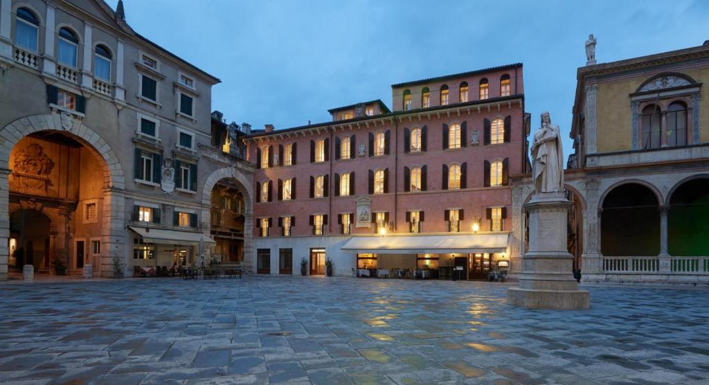 维罗纳Lords of Verona Luxury Apartments的一座城市广场,建筑前方有雕像