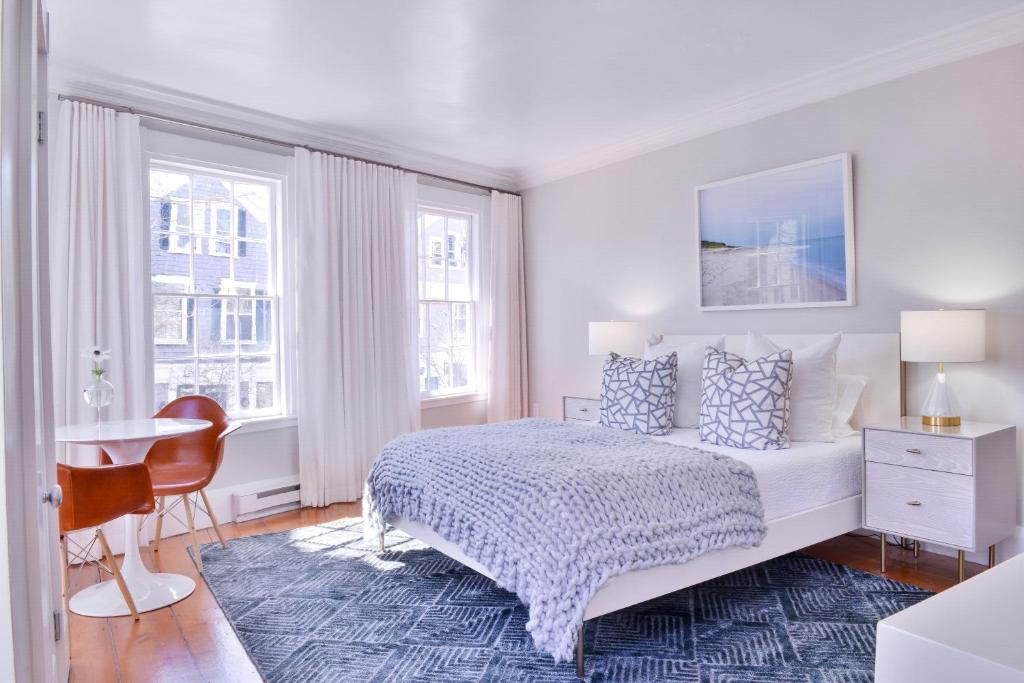 楠塔基特Hotel Pippa的一间卧室配有一张床、一张书桌和两个窗户。