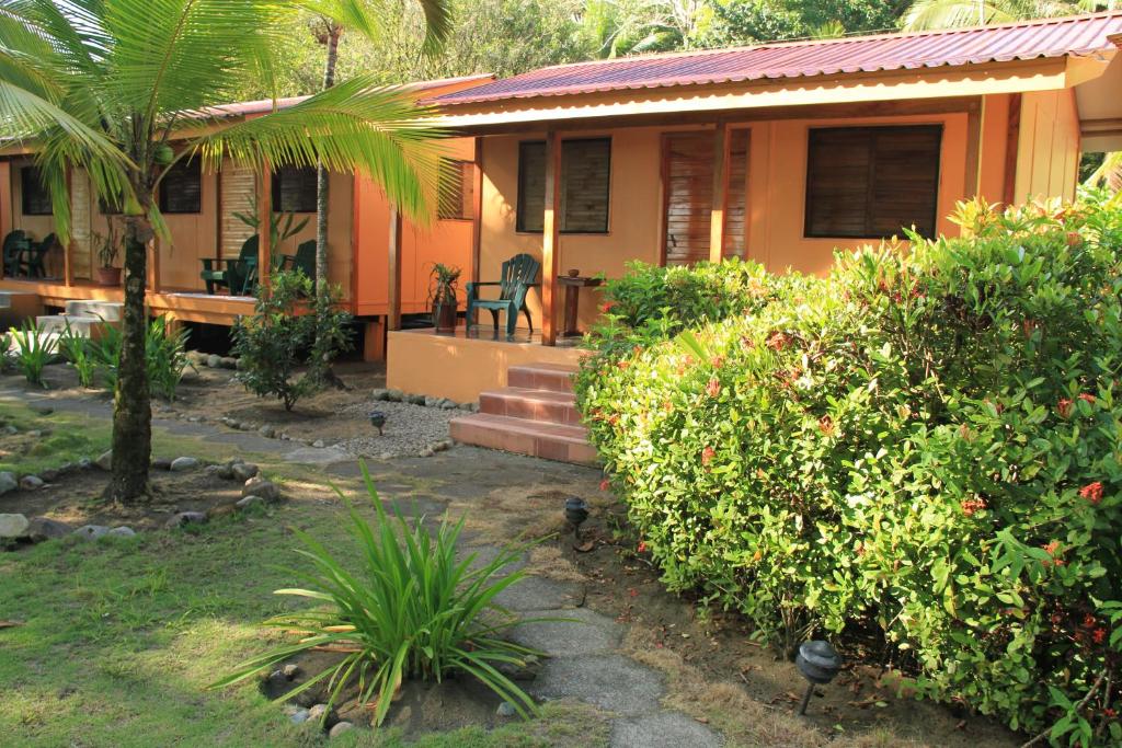 ZancudoCabinas Sol y Mar的一座带门廊和灌木的房子