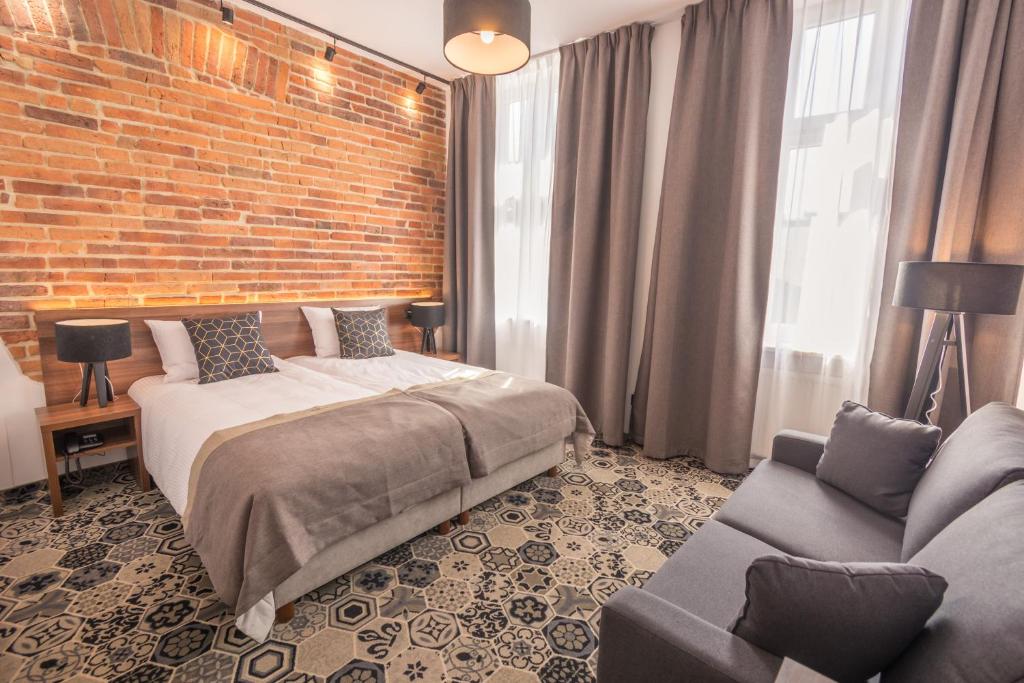 克拉科夫薰衣草酒店的一间卧室设有一张床和砖墙