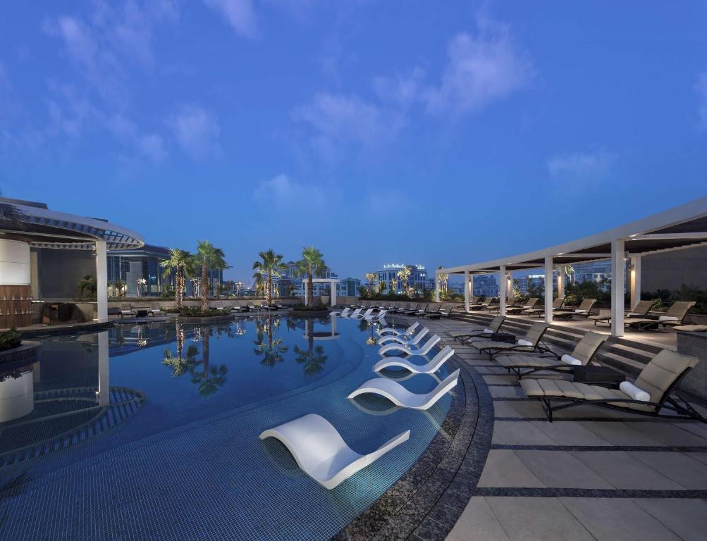 迪拜凯悦迪拜河高地酒店的大楼内一个带躺椅的游泳池