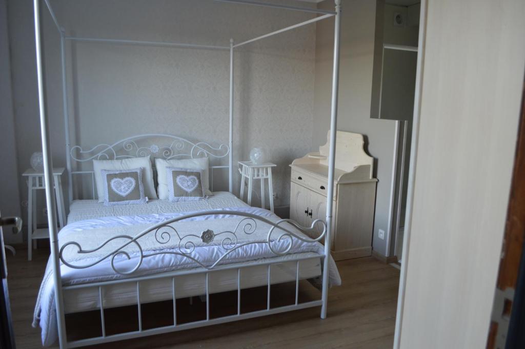 费瑞雷斯Gite Terre de ciel的卧室配有带枕头的白色天蓬床