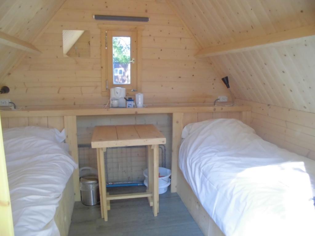 于尔克Vakantiepark 't Urkerbos - Kabouterhuisje的小屋内带两张床和一张桌子的房间