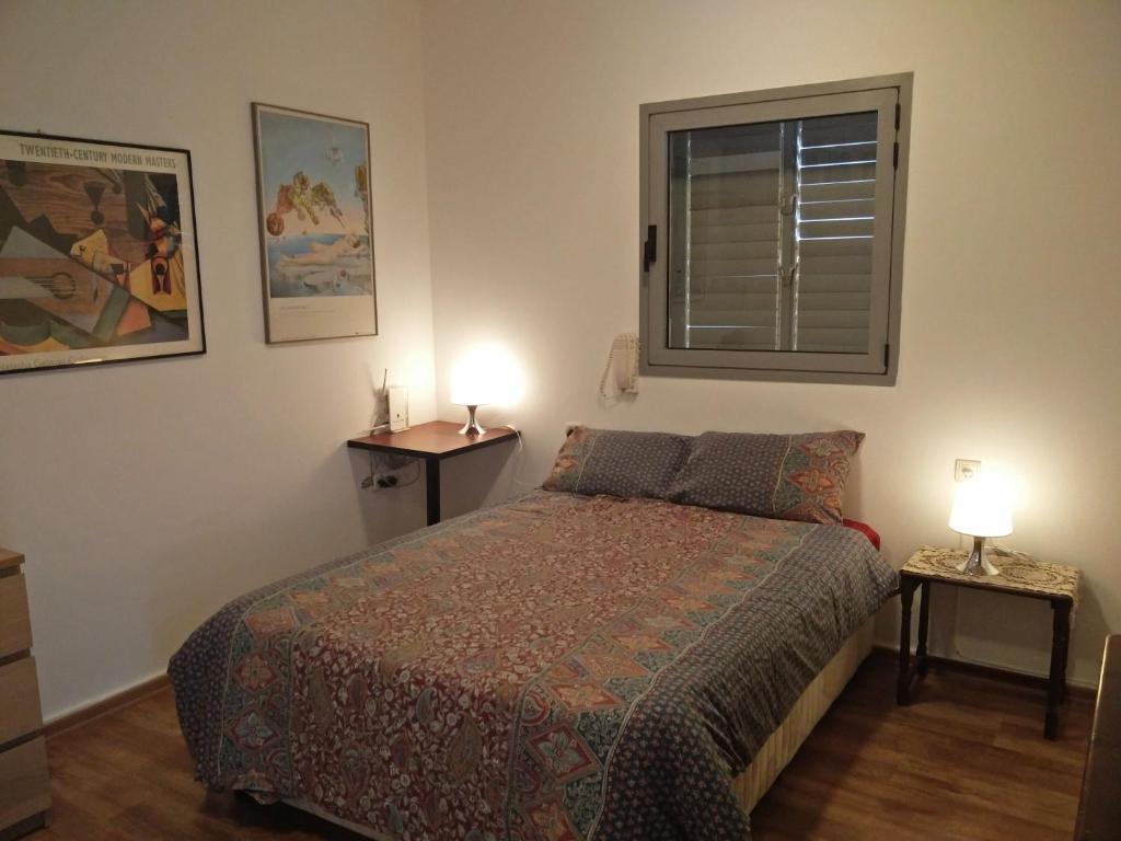 荷兹利亚Herzelia Rooftop Special 2 Room Apartment的一间卧室配有一张床和两张台灯。
