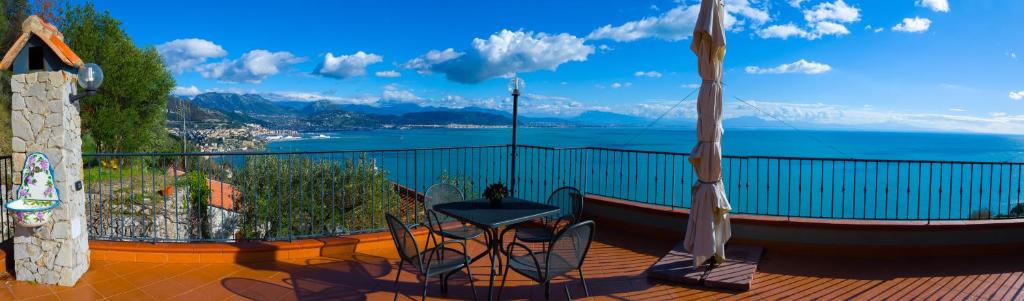 切塔拉Il Glicine的阳台配有桌椅,享有水景。