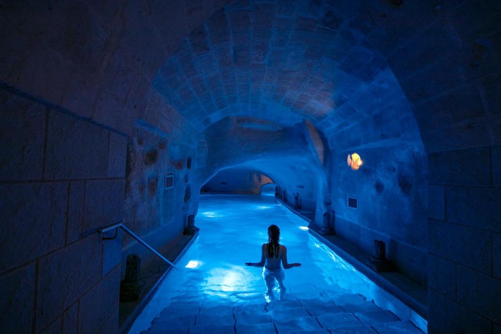 马泰拉洛坎达第圣马蒂诺罗曼尼温泉酒店的站在蓝色隧道中的人