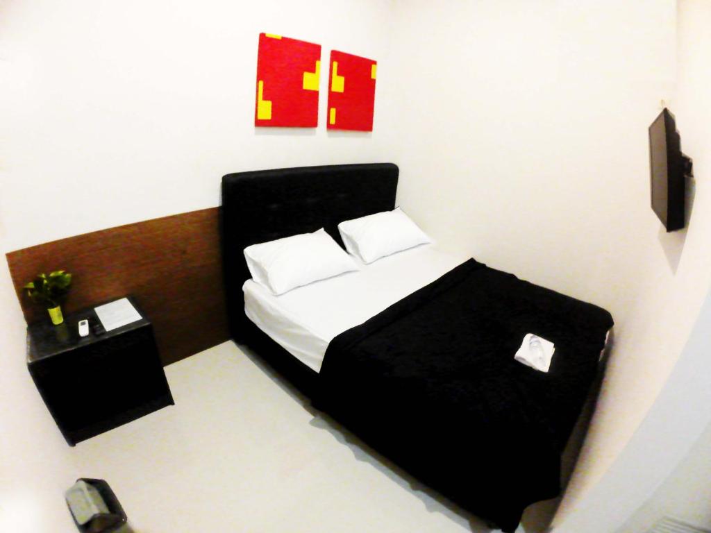 茉莉芬login homestay的一间卧室配有一张带两个白色枕头的黑色床。