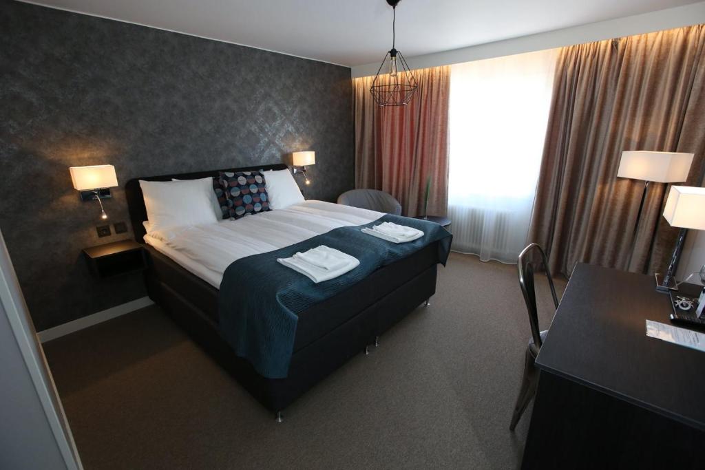 赖特维克Hotell Rättvik的酒店客房,配有带两条毛巾的床
