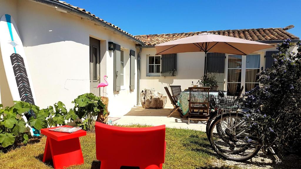圣克莱门特德巴Villas Ré Locations Vacances的一个带遮阳伞和桌椅的房子