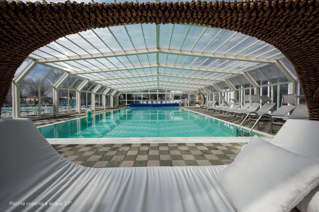 佩斯基耶拉德加达Camping Da Giovanni的一个带椅子和玻璃天花板的大型游泳池