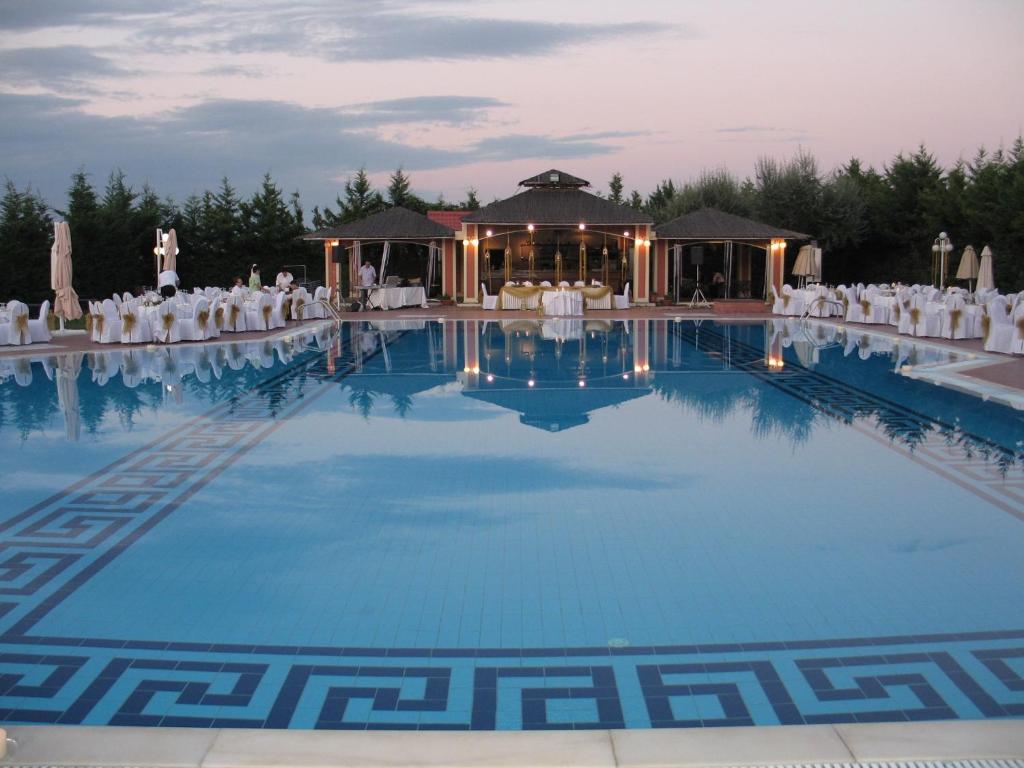韦里亚艾吉斯梅拉松酒店的婚礼场地,带白色椅子的大型游泳池