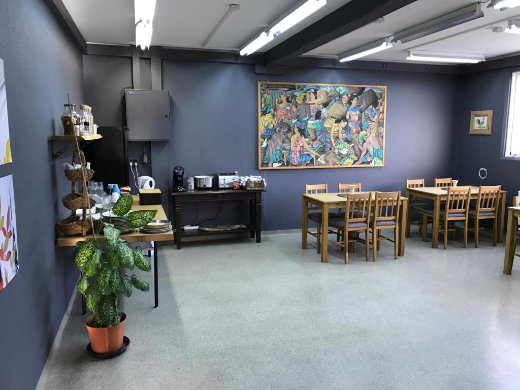 凯夫拉维克Blue Viking Studios的一间设有桌椅的房间和墙上的绘画