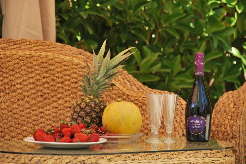 科尔萨诺Villa Verde的一张桌子,上面放着一盘水果和一瓶葡萄酒
