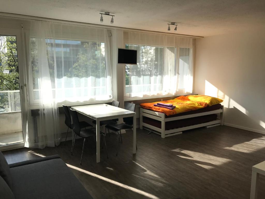 楚格Anstatthotel Zug - self-check-in的一间卧室配有一张床、一张桌子和一张桌子