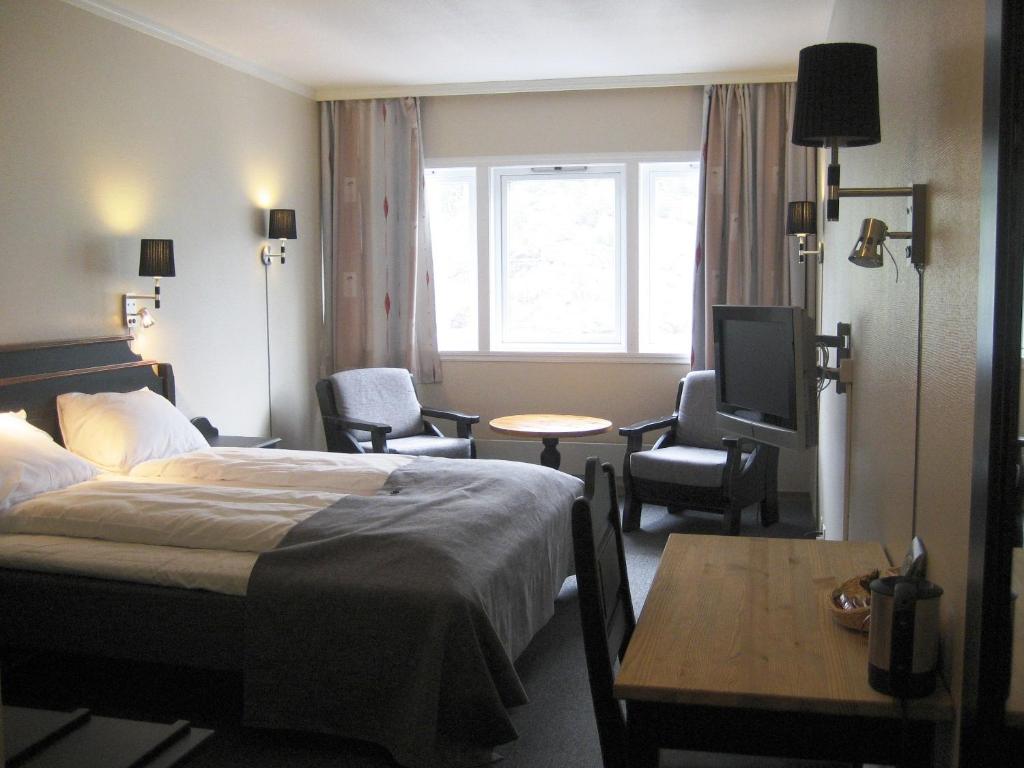 Bromma诺克鲁汽车旅馆的一间酒店客房,配有一张床铺、一张桌子和一台电视