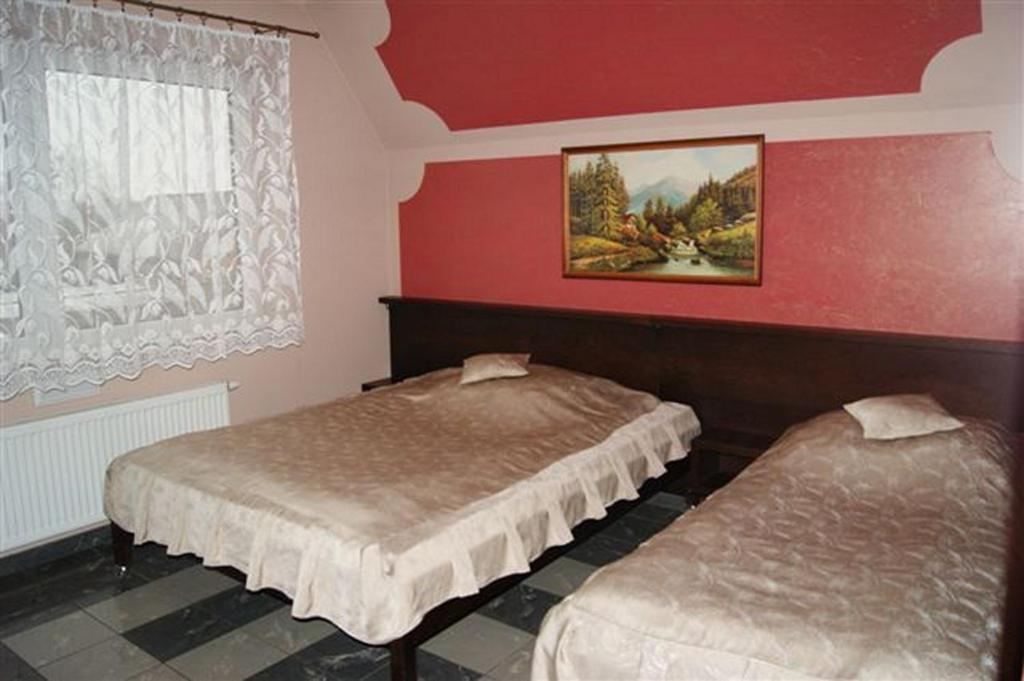 Biskupice珀柯杰戈瑟林贾姆酒吧旅馆的红色墙壁客房的两张床