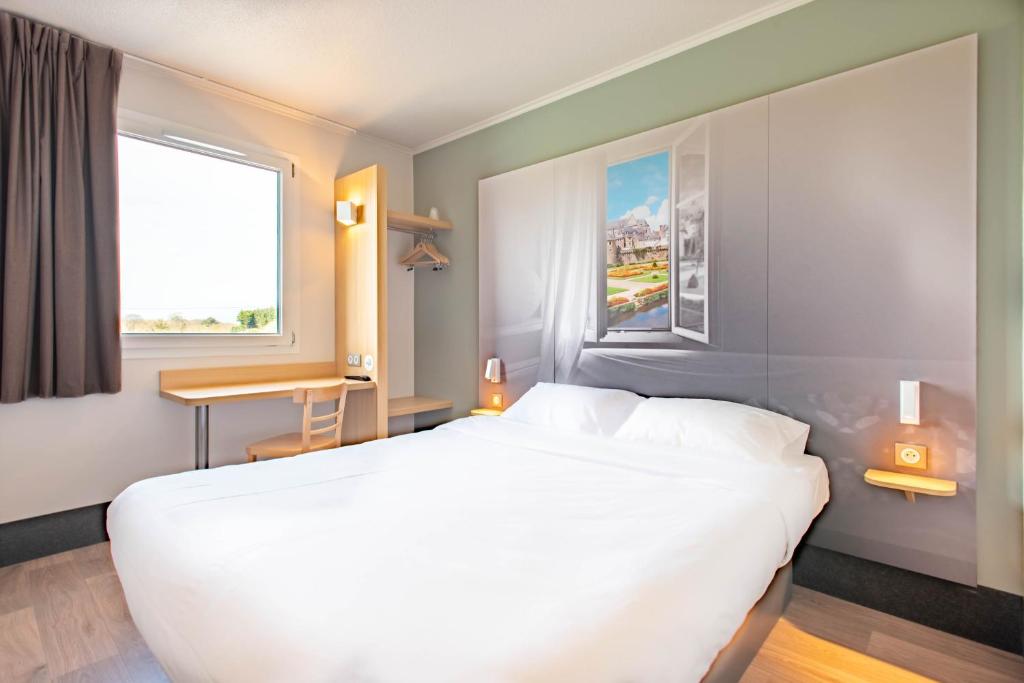 瓦讷B&B HOTEL Vannes Ouest Golfe du Morbihan的卧室设有一张白色大床和一扇窗户。