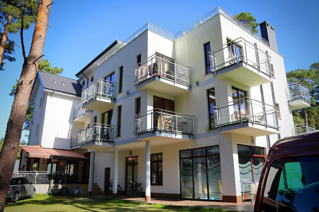 波别罗沃Villa Reza的白色的建筑,设有两个阳台