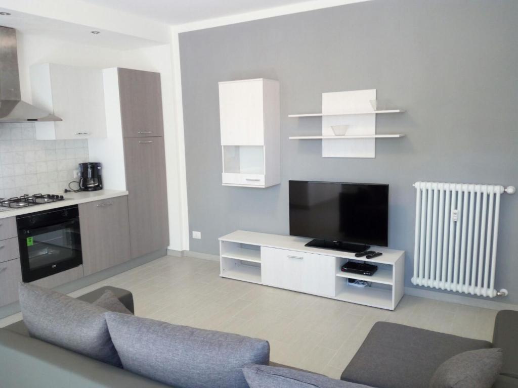 卡尼洛瑞维拉Appartamento FIORE的带沙发和电视的客厅以及厨房。
