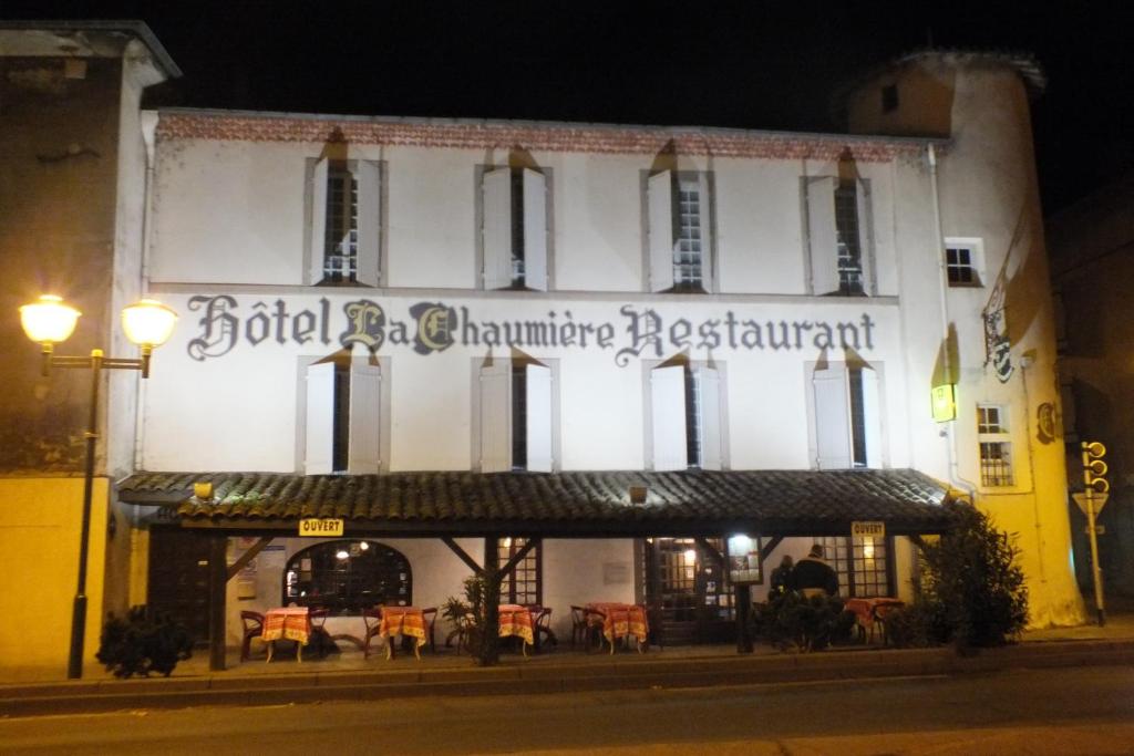 罗纳河畔的图尔农Hotel Chaumiere -的一座有夜间餐厅标志的建筑