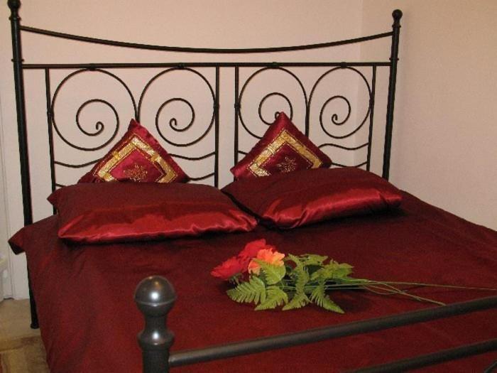 皮瑟兹诺皮瑟兹诺古老的波兰别墅旅馆的一张带红色枕头的床,床上有鲜花