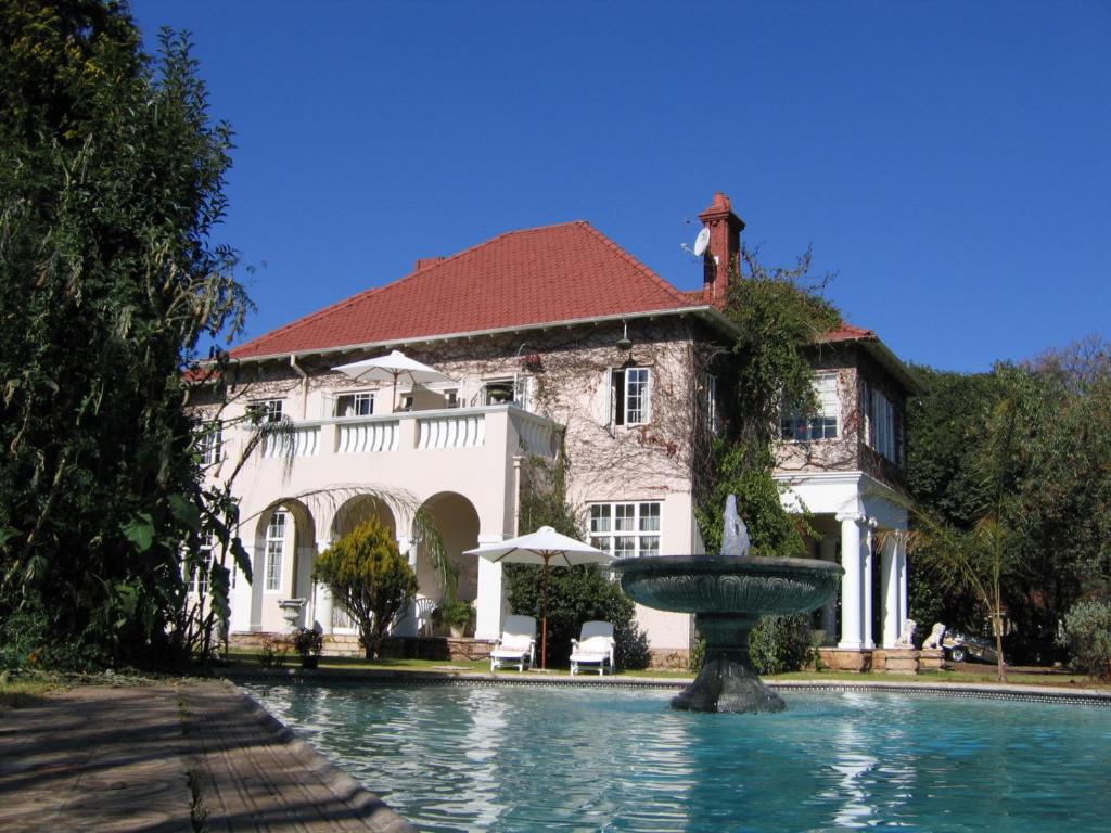 伯诺尼Villa Victoria executive Guest House的一座大房子前面有一个喷泉
