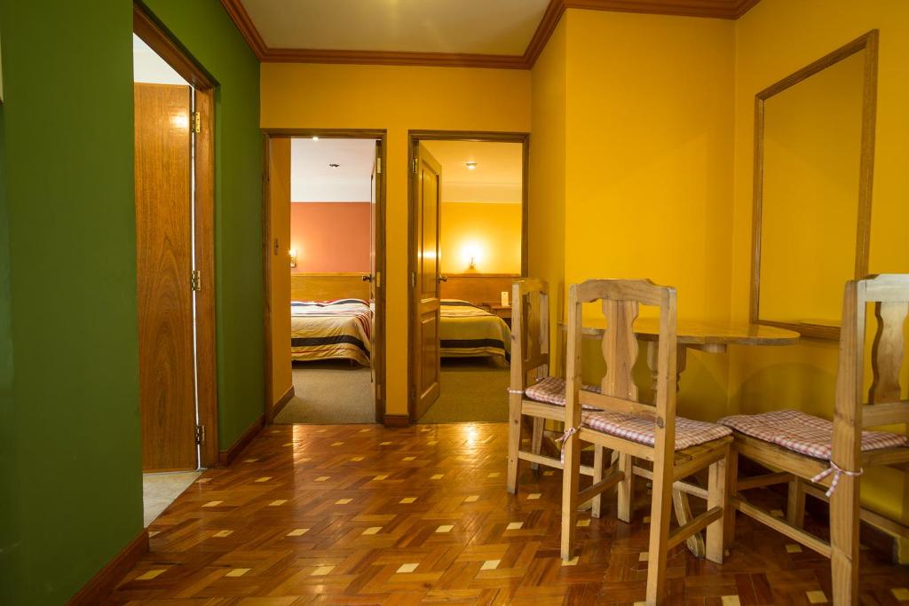 波托西西玛阿根特姆酒店的客房拥有黄色和绿色的墙壁,配有桌椅