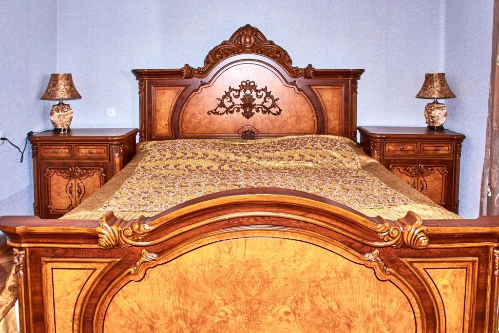 哥里Guest House Svetlana的卧室内一张大型木床,配有两盏灯