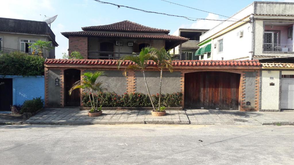 里约热内卢Nacif's Suites的前面有棕榈树的房子