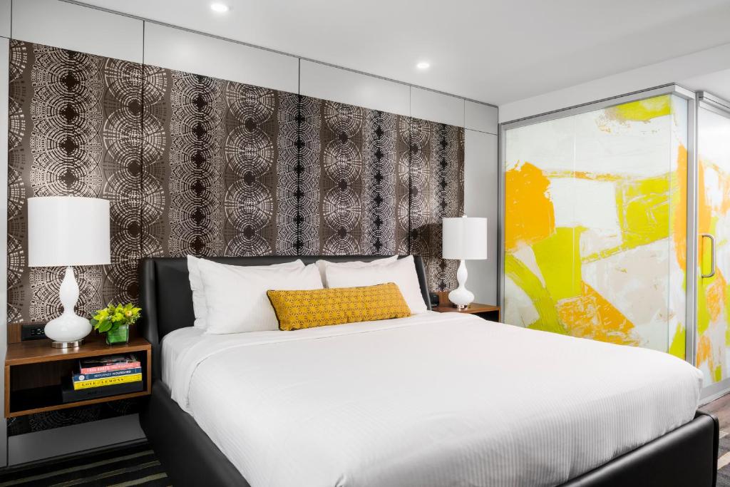 卡尔加里艺术酒店的卧室配有白色的床和黄色枕头