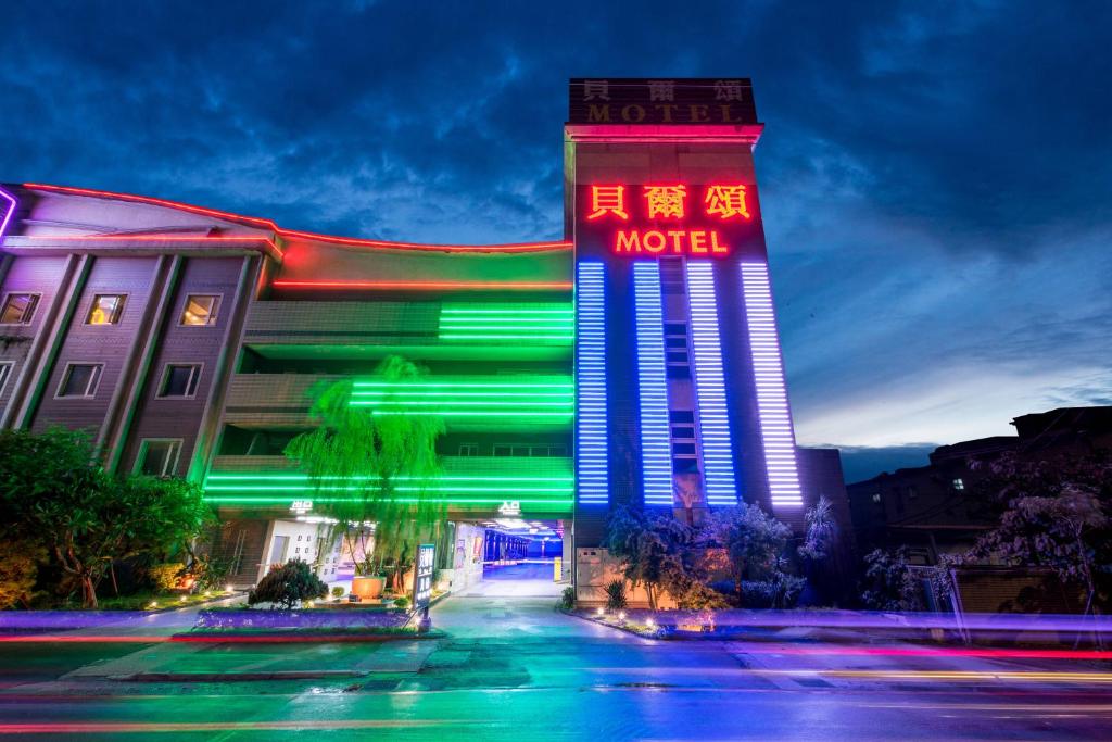 树林区贝尔颂精致汽车旅馆的前面有 ⁇ 虹灯标志的酒店