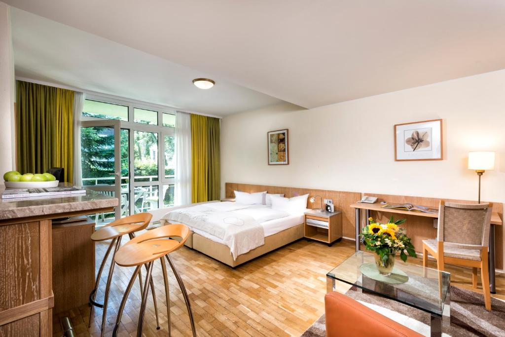 柏林Westlife Apart Hotel Berlin的酒店客房带一张床、一张桌子和椅子