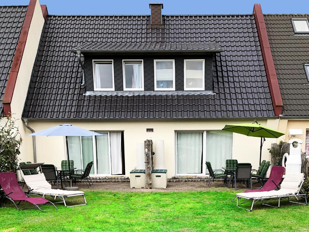 普鲁滕Haus Pruchten的院子里带椅子和遮阳伞的房子